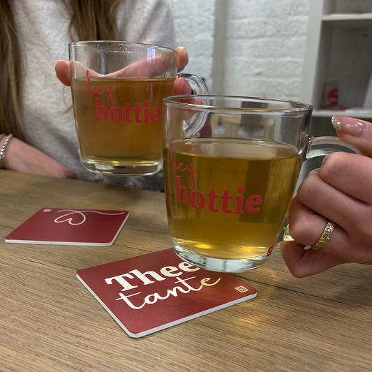 twee mensen die thee drinken uit theeglazen met opdruk hey hottie